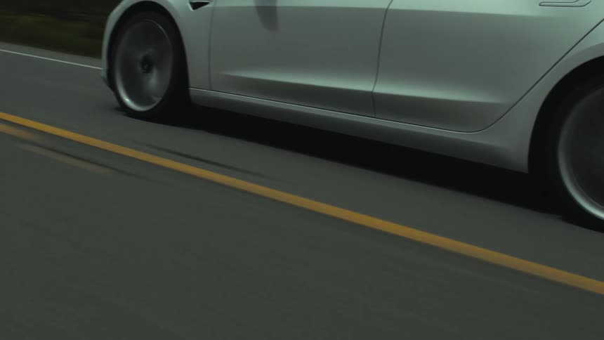 A car driving down a road past trees