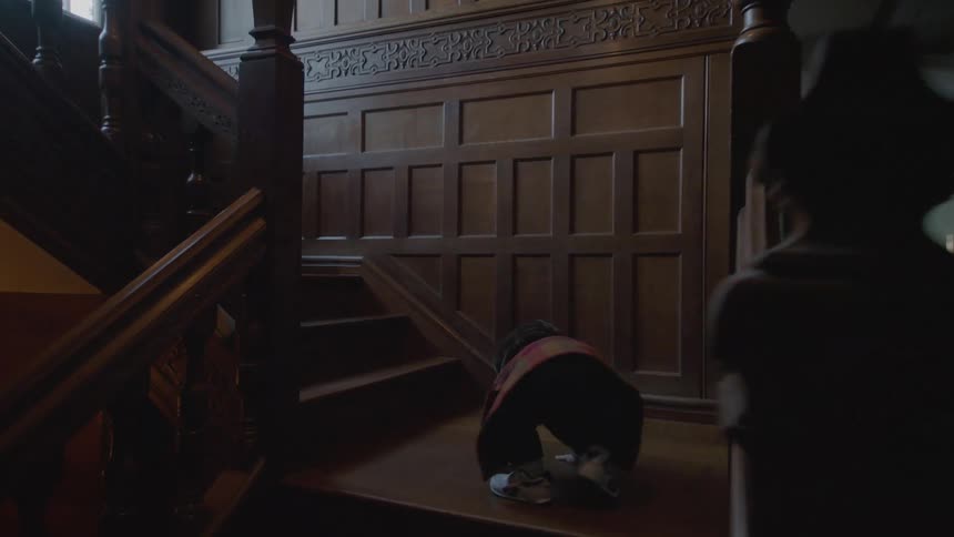 A boy climbs up the stairs in his house