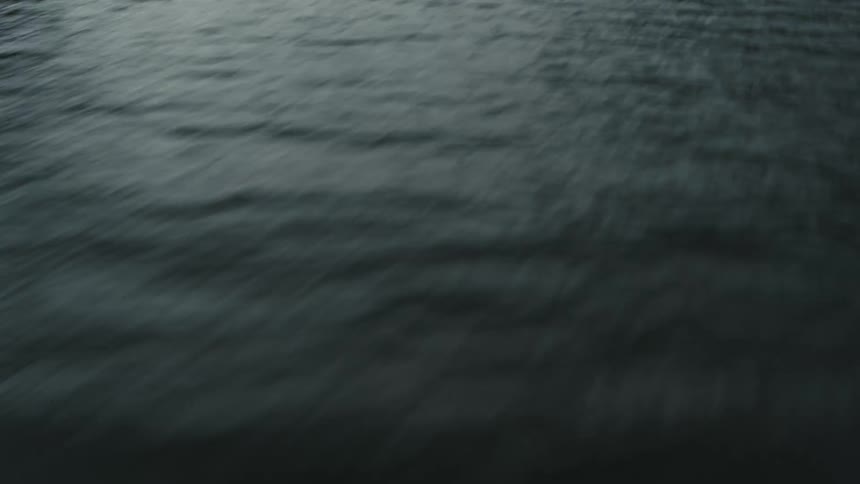 Aerial view of the surface of a lake in the mountains on an overcast day