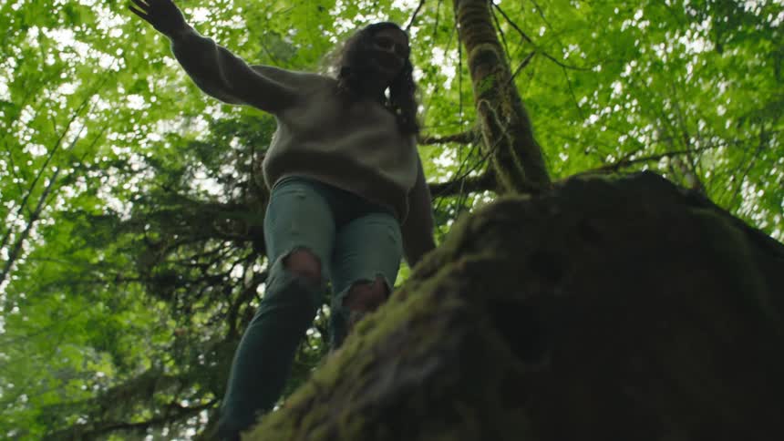A woman balances on the log
