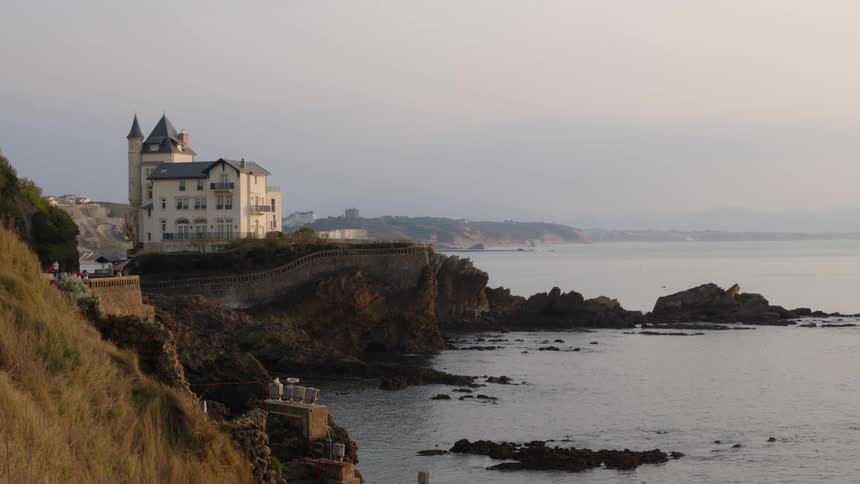 Aerial view of a building near the ocean coast is displayed