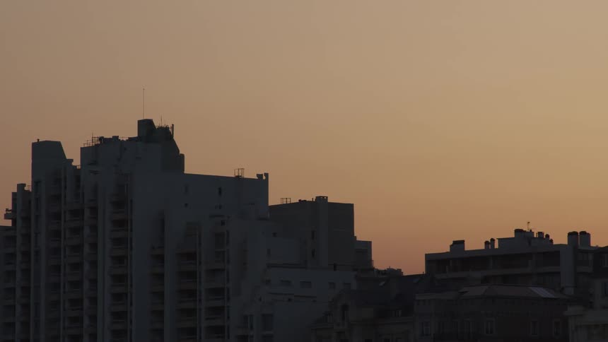 Large buildings in a city at sunset