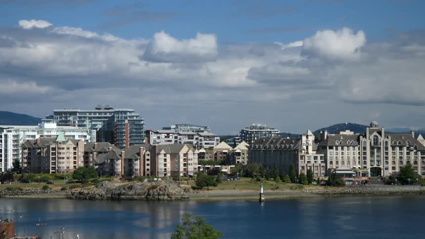 Boats float on a lake with buildings in the background