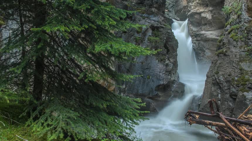 Time lapse of the side of a mountain with a stream running down