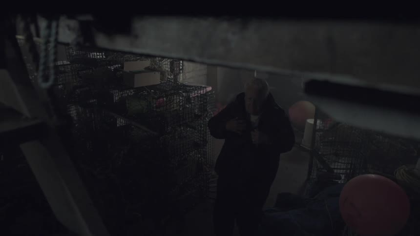 A man puts on his coat in a dark room