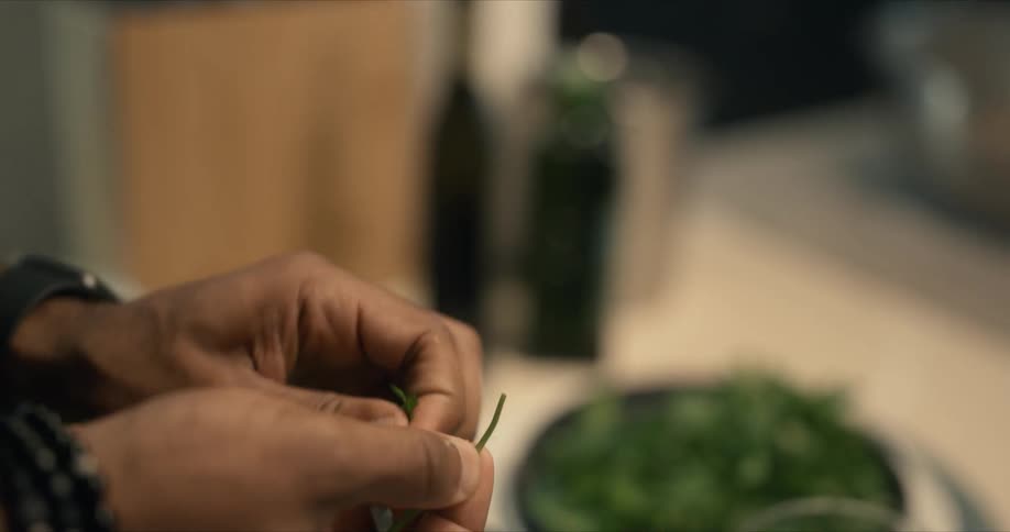 A man tears herbs off the stem