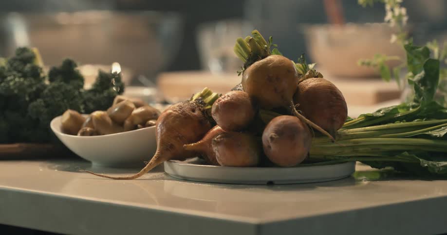 Produce organized by type sit on plates and bowls on a kitchen counter