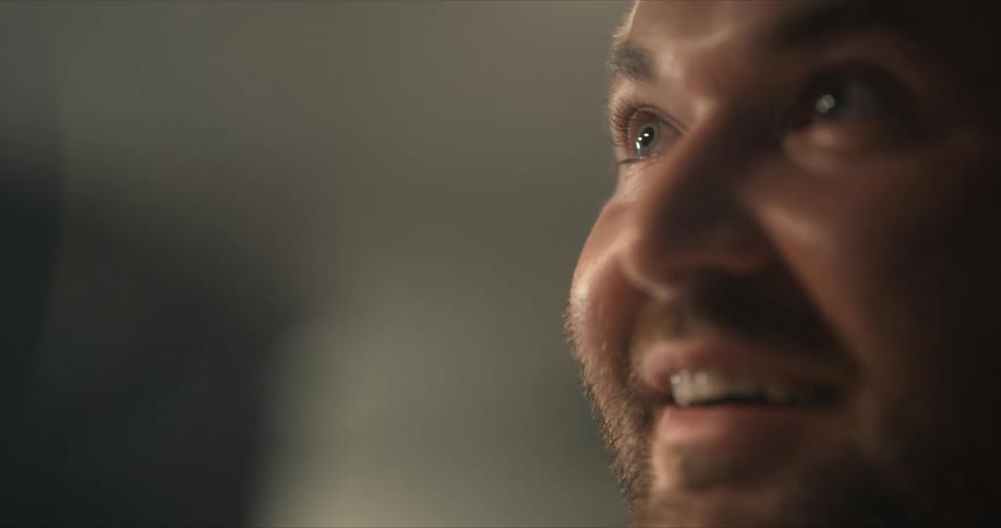 A man looks up with a big smile and gleaming eyes