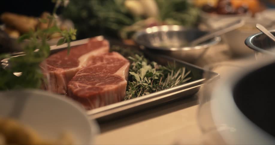 Steaks sit in the pan on the counter