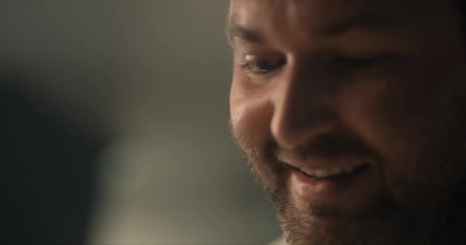 A man smiles and talks