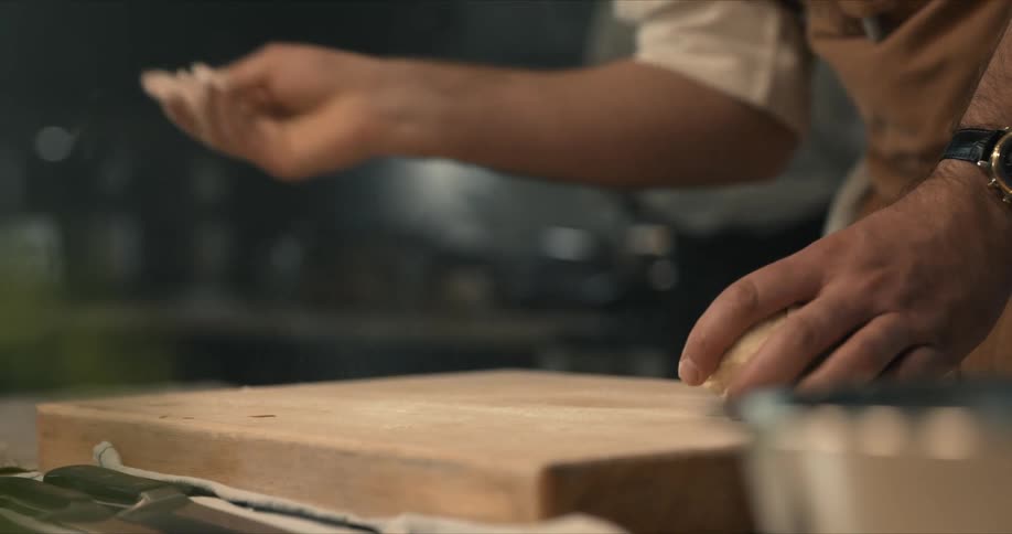A chef is kneading a ball of dough