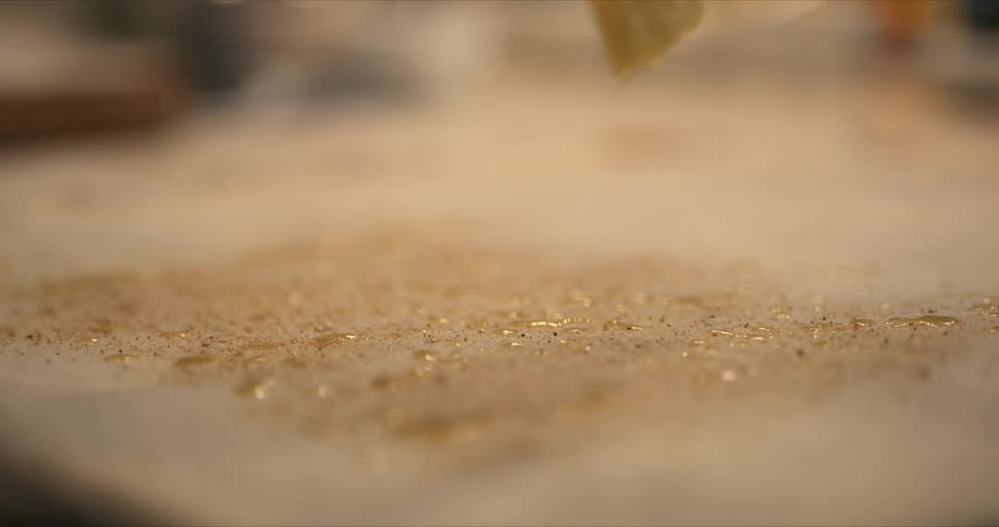 Oil is sprinkled on the sheet of dough