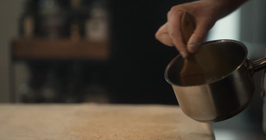 A cook is dribbling oil on the dough