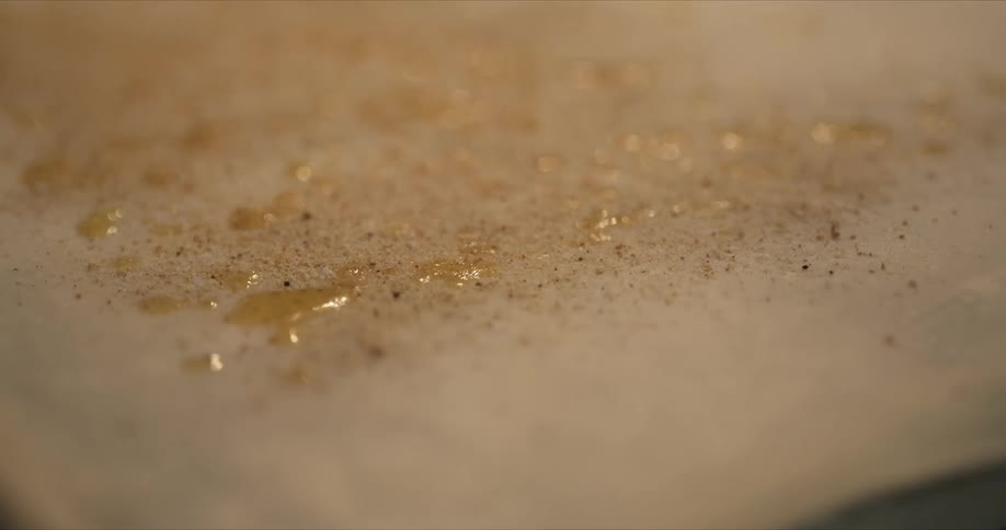 Splashes of oil and spices sit on top of rolled out dough
