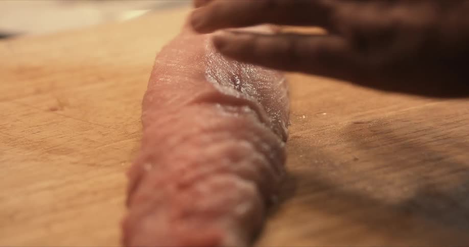 A person is cutting fish with a knife