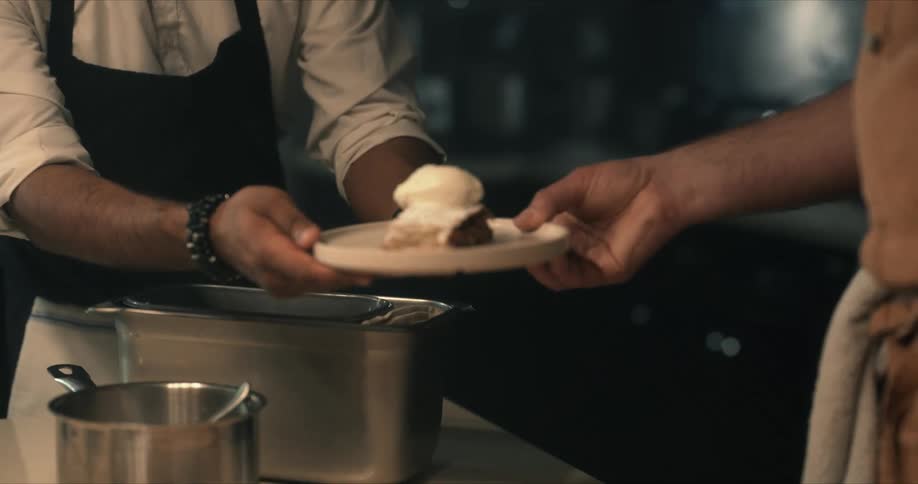 A chef displays a dish and sends it off for service