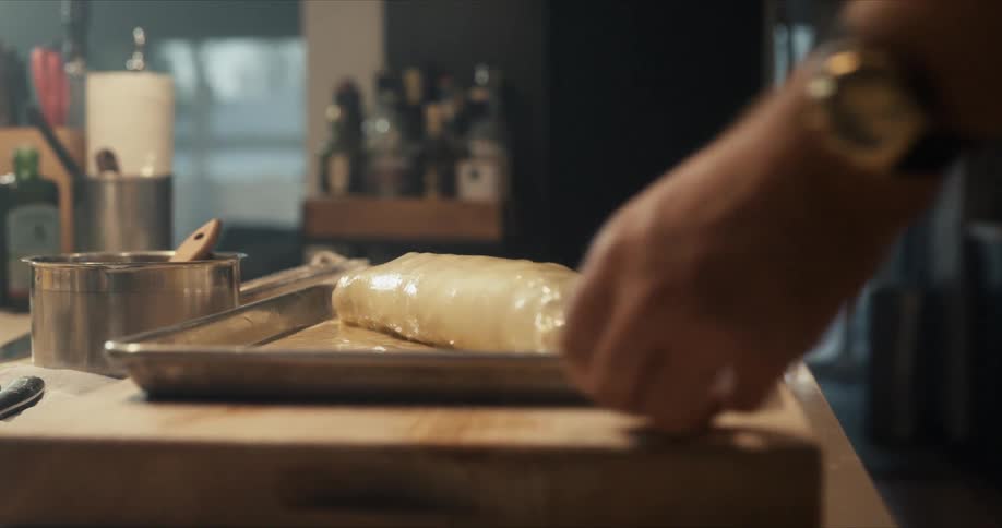 A chef is basting food in the pan