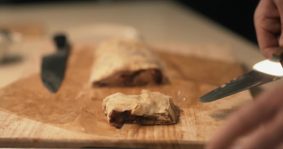 A man is cutting pastry into individual servings