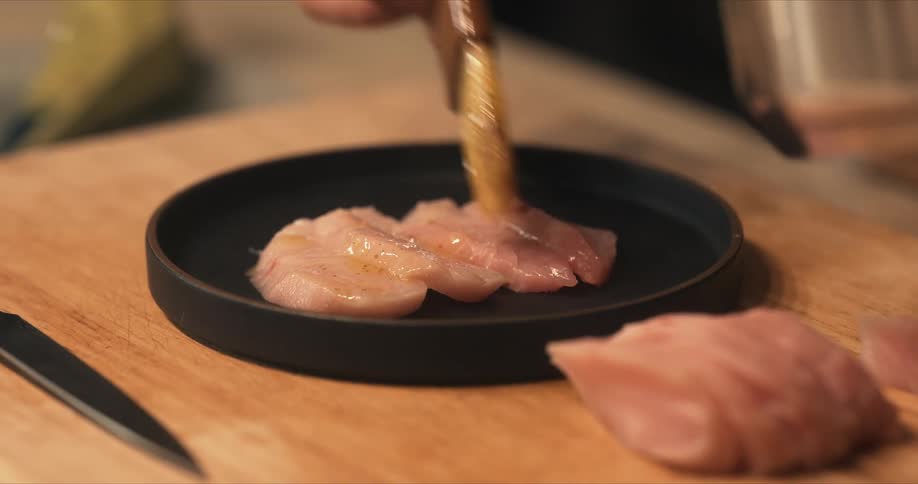 A cook is basting fish on the plate