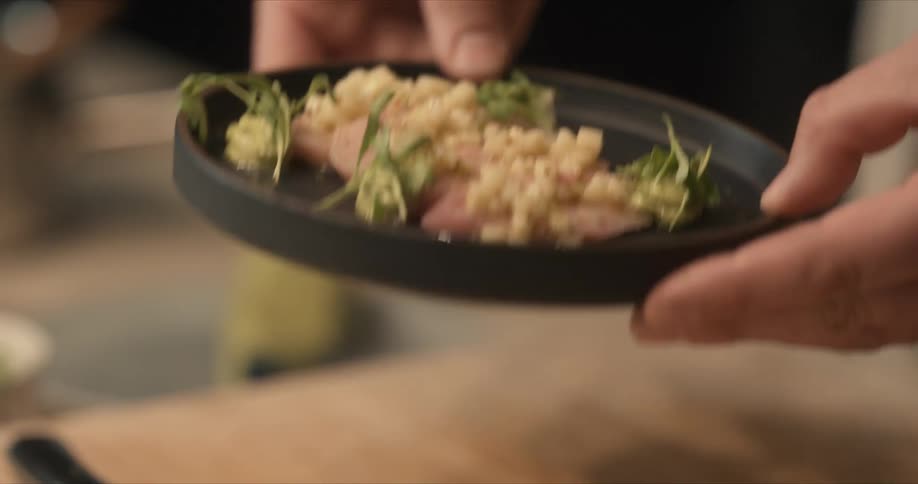 Chef shows a finished dish prepared on the kitchen
