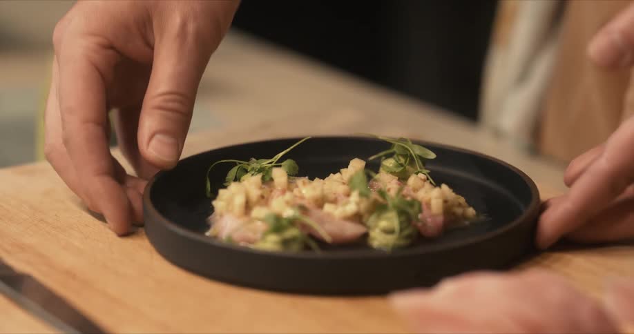A view of a person putting food on a plate