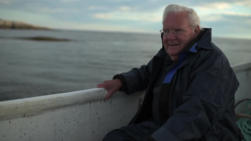 A man sits in a boat holding onto the side