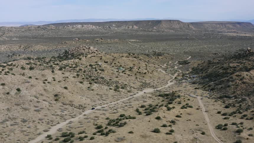 A vehicle travels through the desert