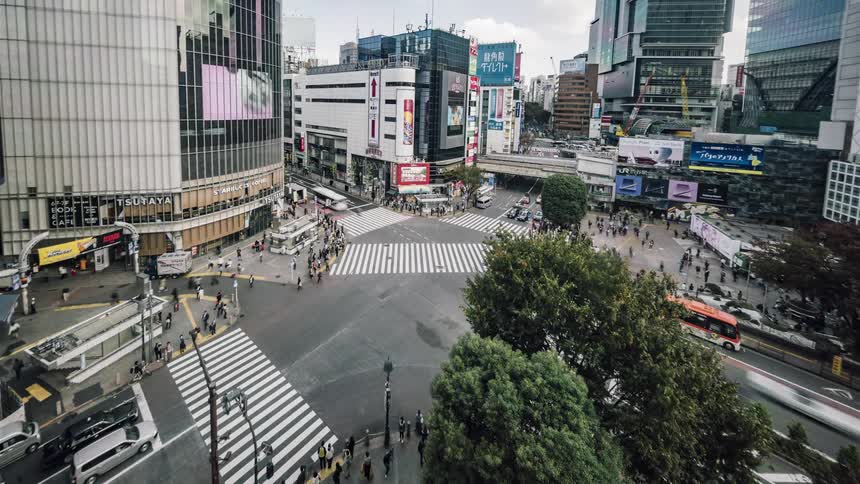 Pedestrians and vehicles move through the city