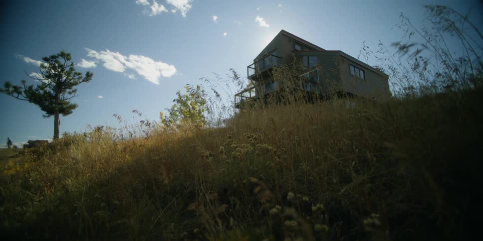A large house on the top of a hill in the countryside during the day