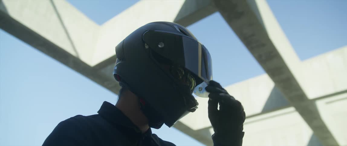 A man is wearing a motorcycle helmet outdoors