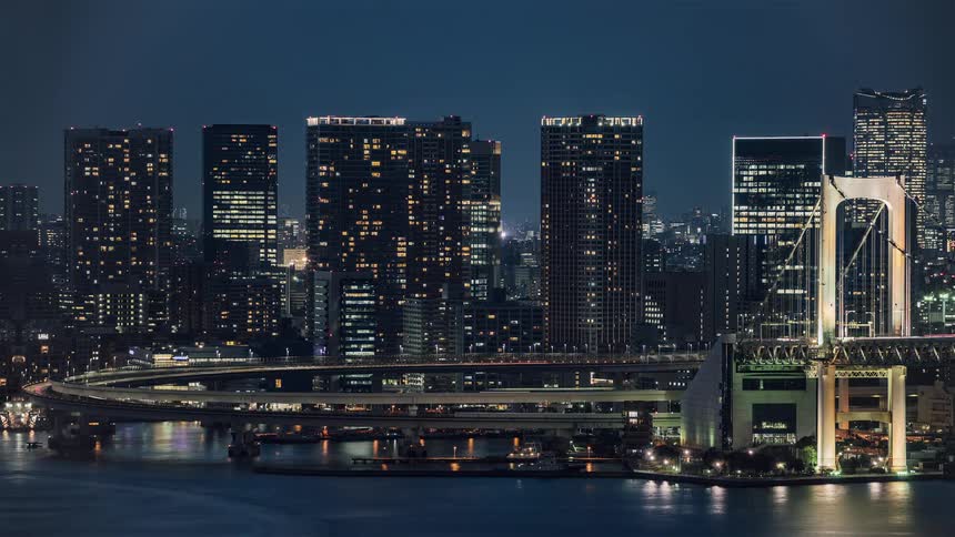 Boats passunder busy oval highway bordered by downtown skyscrapers and the a suspension bridge
