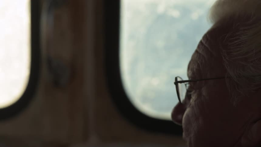 A man sits smiling in a boat interior