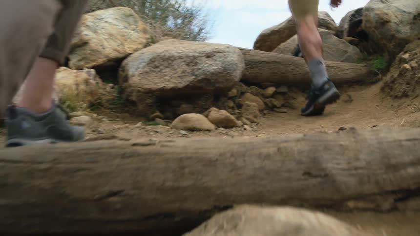 Hikers climb rough incline and reaching top are met with view of canyon