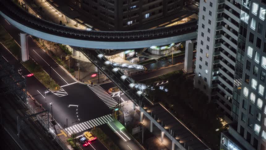 Traffic travels through an intersection in a metropolis at night