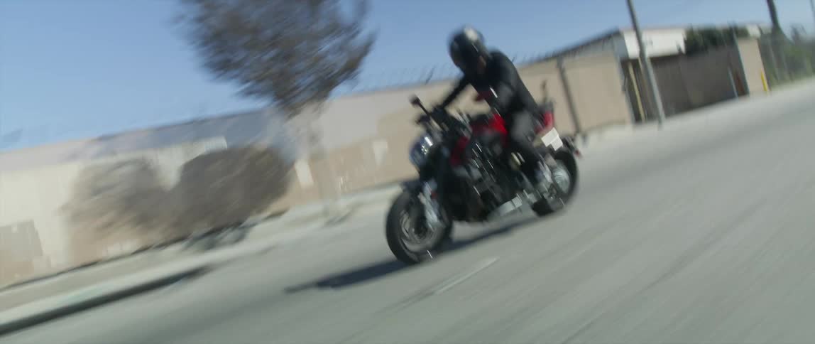 A motorcyclist speeds down an empty city street
