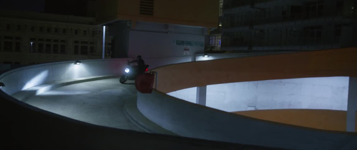 A person rides down the ramp in the parking garage
