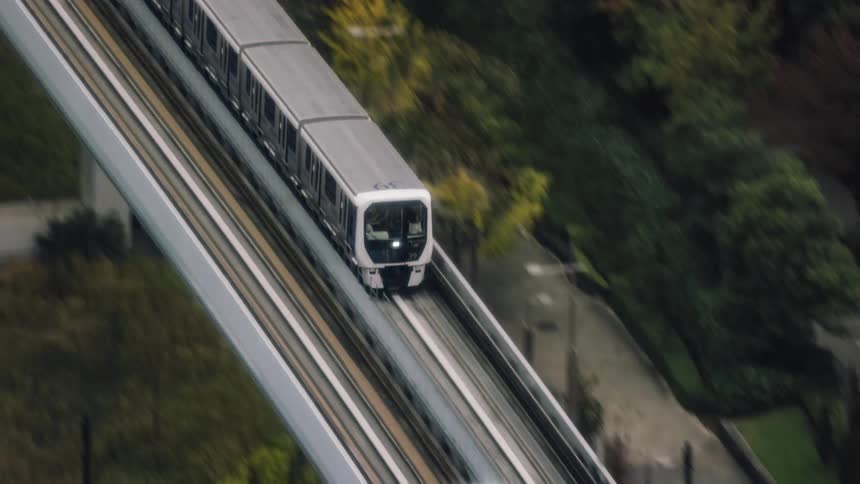 A commuter train travels down an elevated track