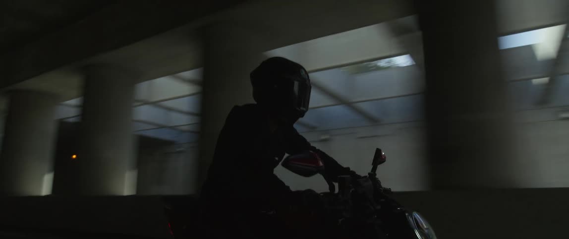 A person rides their motorcycle through the tunnel