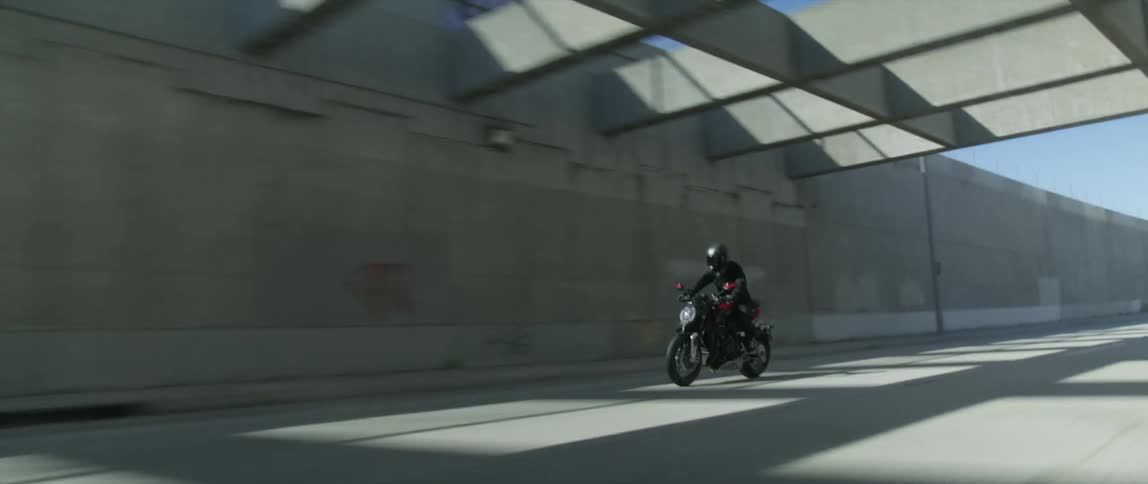 A person rides their motorcycle into the tunnel