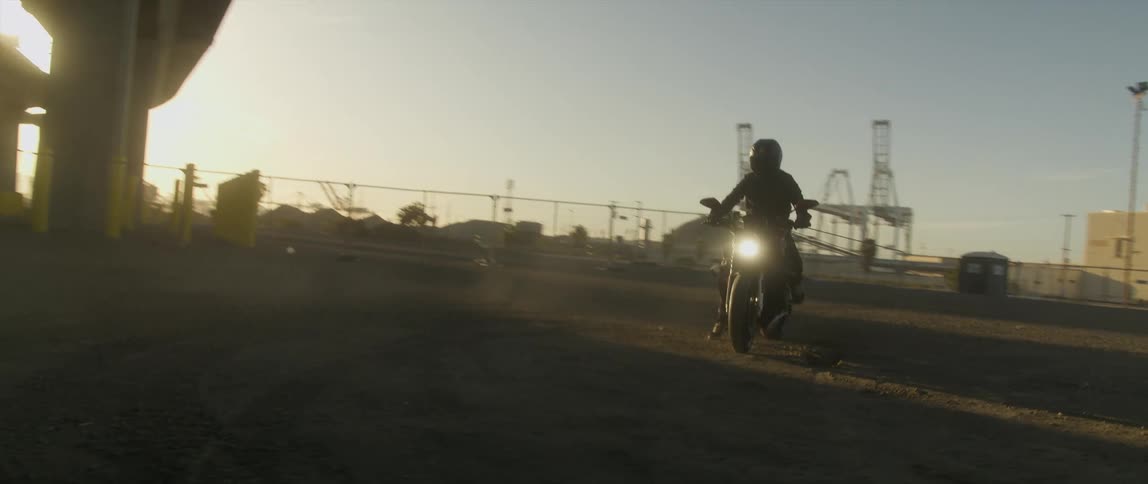 A man sits on his motorcycle in the lot