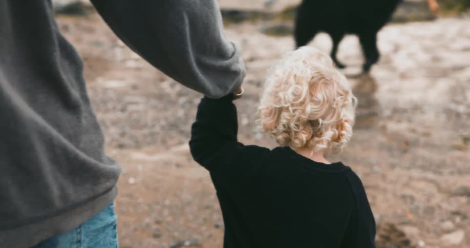 A mother is walking with her daughter and dog
