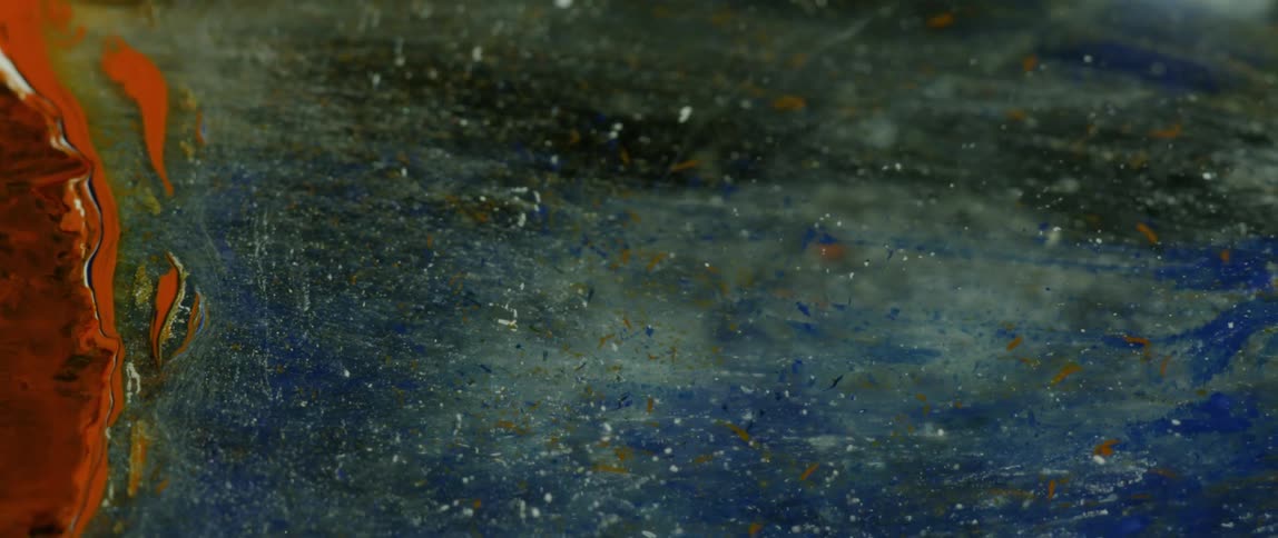 Paints combine and swirl together in specks and puddles