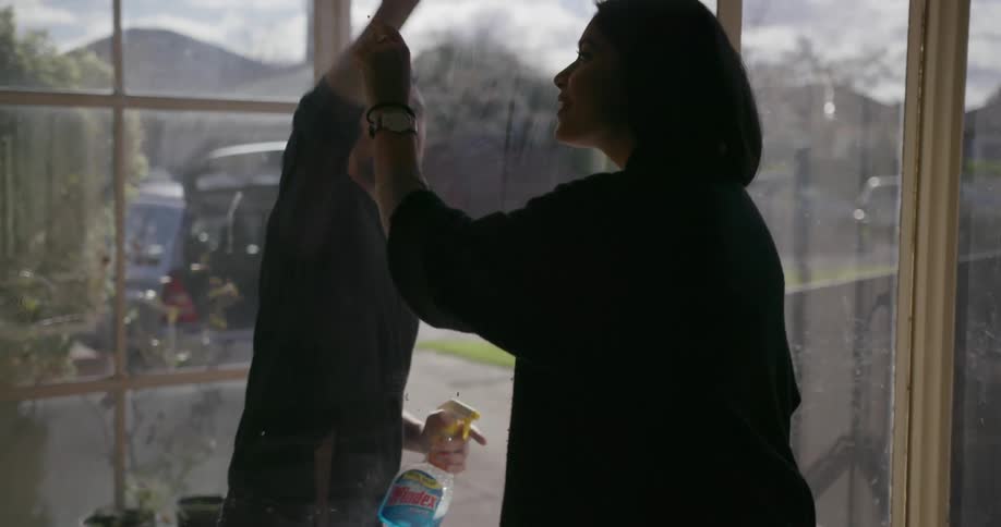 A man and woman wash windows