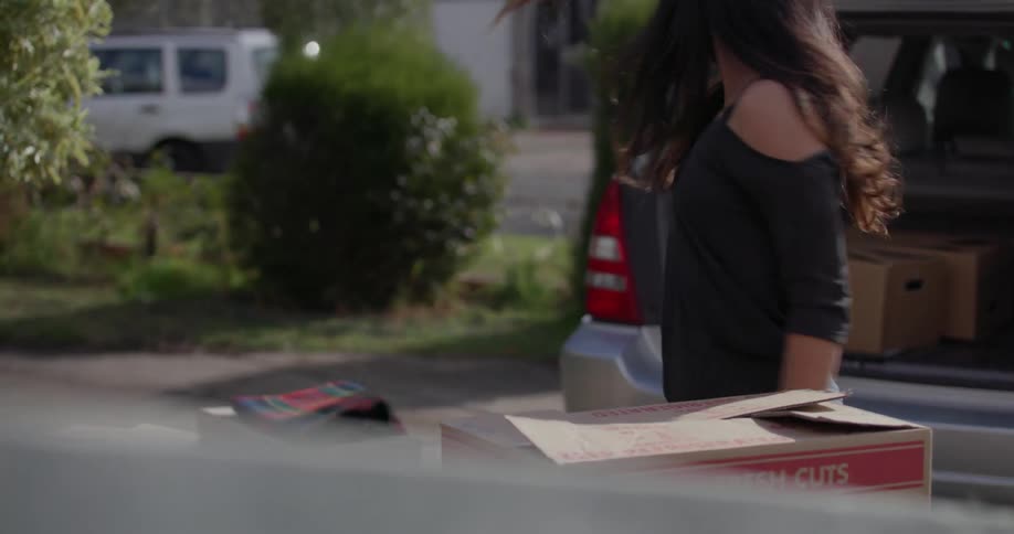 A man and woman unload boxes from a car