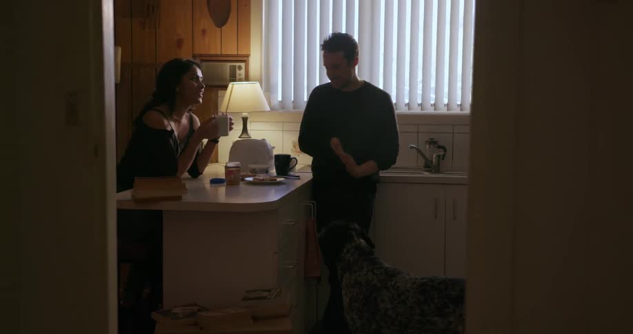 A man and woman feed treats to their dog