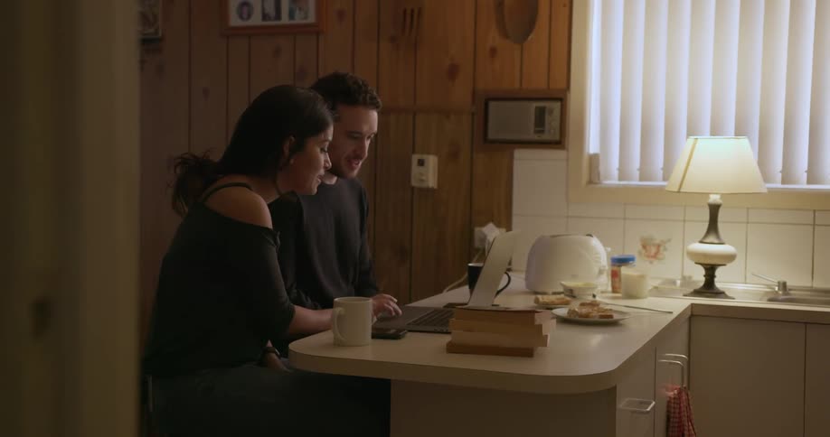 A couple works at a laptop