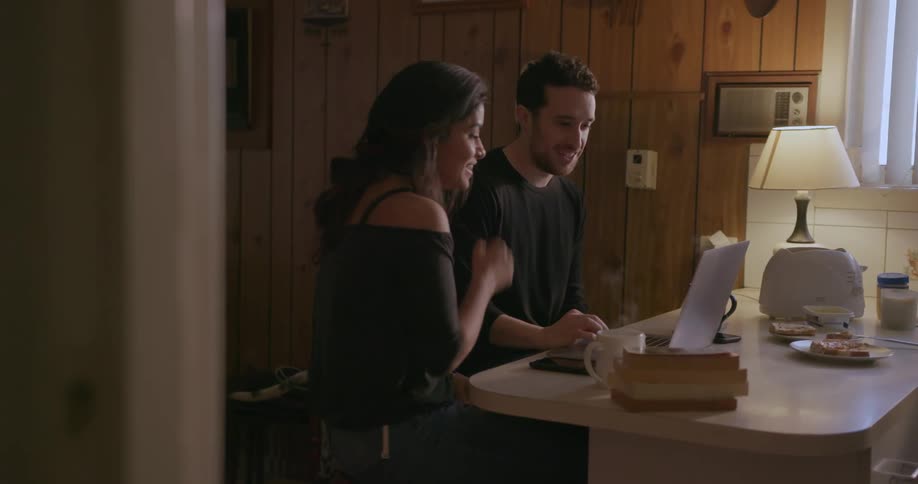 A man and woman sit at a kitchen counter