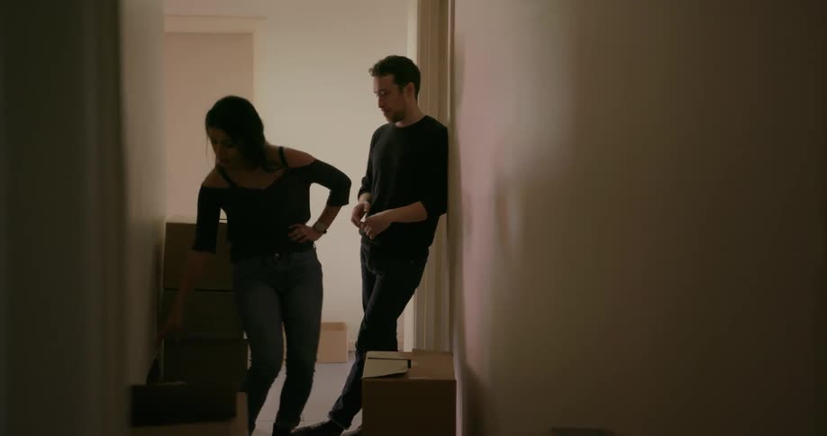 Man and woman talk while moving into a house