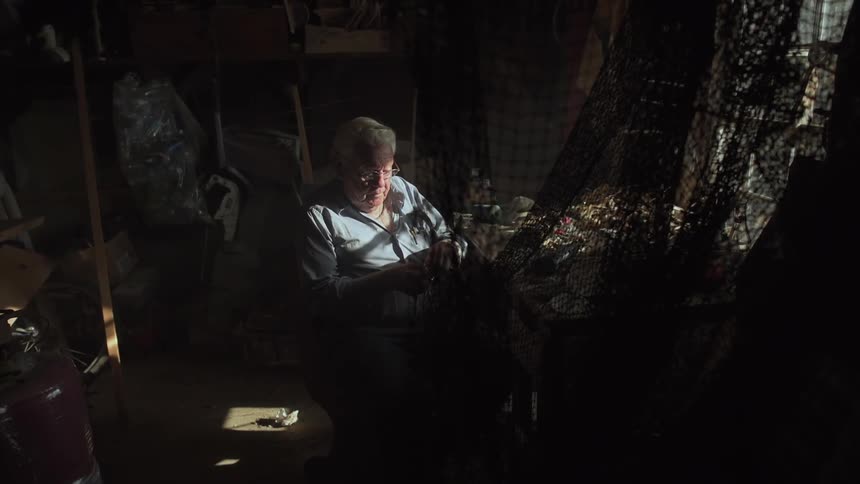 A man sits in a dark room