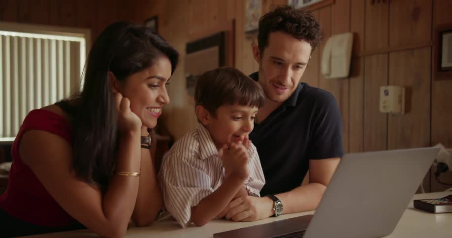A young family looks at a laptop